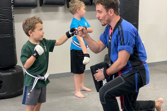 A young martial arts student with his instruction during a class in Action Karate.