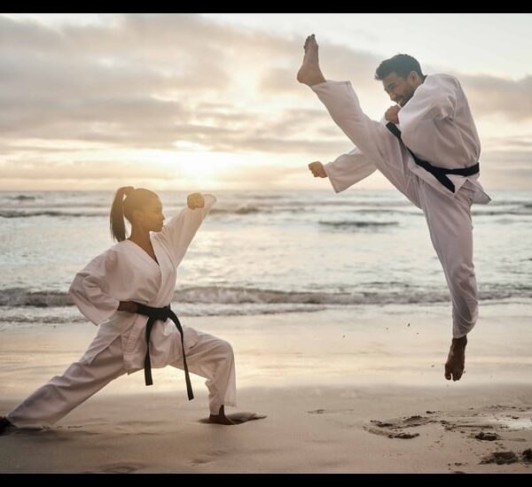 People training karate on the beach.