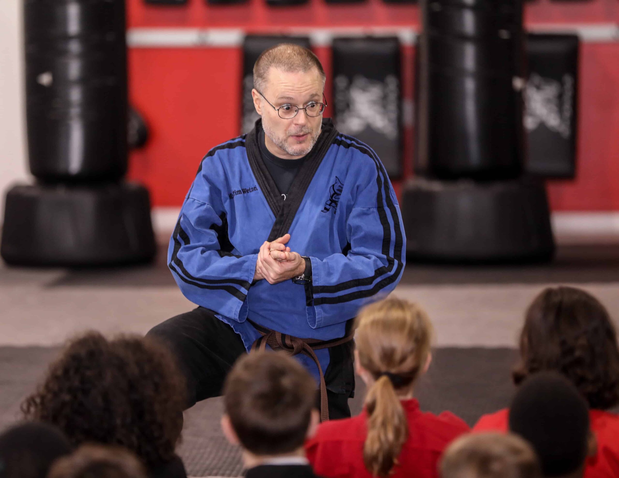 An Action Karate instructor talking to a group of students.