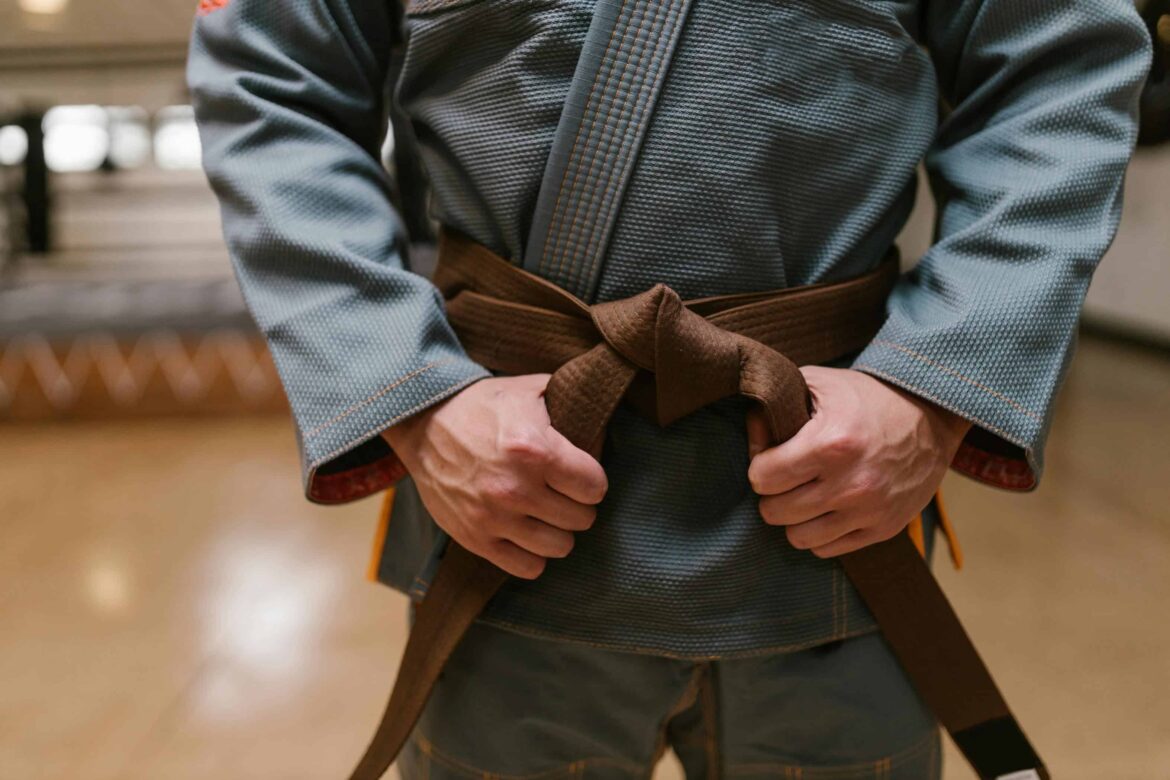 man wearing a karate uniform holding his belt