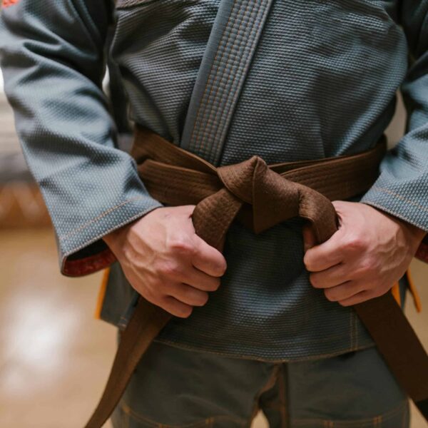 man wearing a karate uniform holding his belt